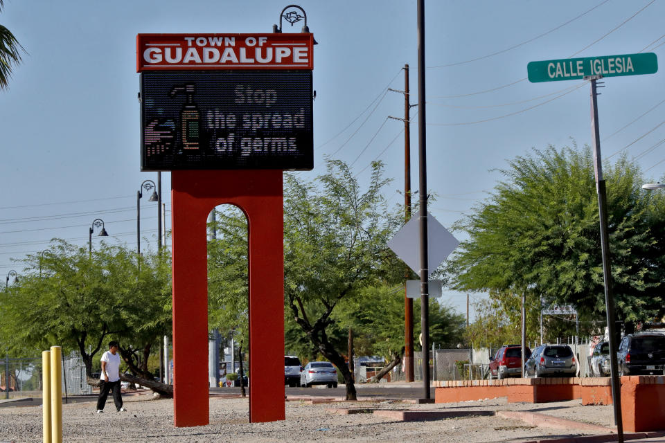 Tn this Thursday, June 18, 2020, photo, a sign encourages hand washing in Guadalupe, Ariz. As the coronavirus spreads deeper across America, it's ravaging through the homes and communities of Latinos from the suburbs of the nation's capital to the farm fields of Florida to the sprawling suburbs of Phoenix and countless communities in between. (AP Photo/Matt York)