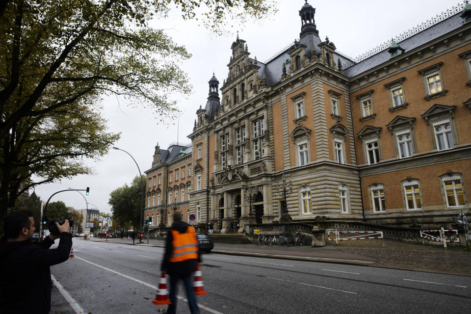 A man walks in front of the criminal court in Hamburg, Thursday, Oct. 17, 2019. 93-year-old former SS private Bruno Dey is going on trial at the court on 5,230 counts of being an accessory to murder, accused of helping the Nazis' Stutthof concentration camp function. (AP Photo/Markus Schreiber)