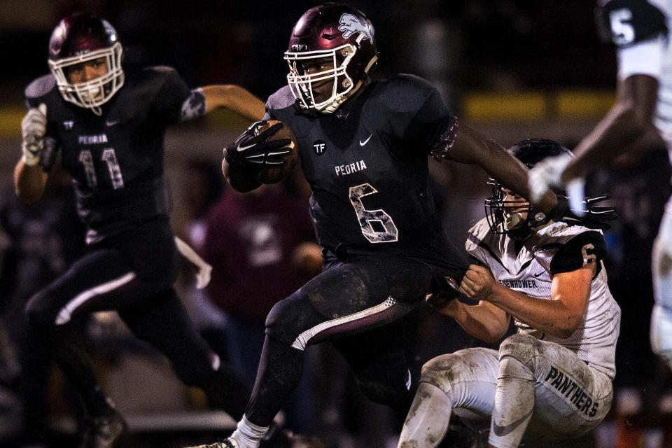 Peoria High running back Jaleen James (6) runs downfield for a long gain as Decatur Eisenhower's Bryson Bonds (6) tries to pull him down during the Lions' 96-40 win against the Panthers in 2016 at Peoria Stadium in the second round of the Class 5A playoffs.