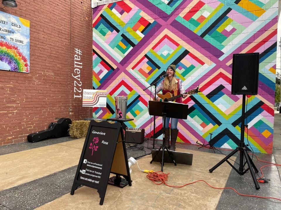 Genevieve Rose performs during the 2022 Morenci Fall Fest. In 2021, the city of Morenci received a Main Street microgrant for its downtown lot reclamation project. With the grant, the Revitalize Morenci Initiative committee alongside a group of residents transformed an empty lot through the installation of an interactive mural, seating and picnic areas.