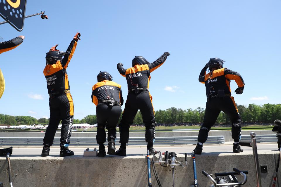 Members of Pato O'Ward's No. 5 Arrow McLaren SP crew celebrate as their driver nears the finish line to win Sunday's IndyCar race at Barber Motorsports Park.
