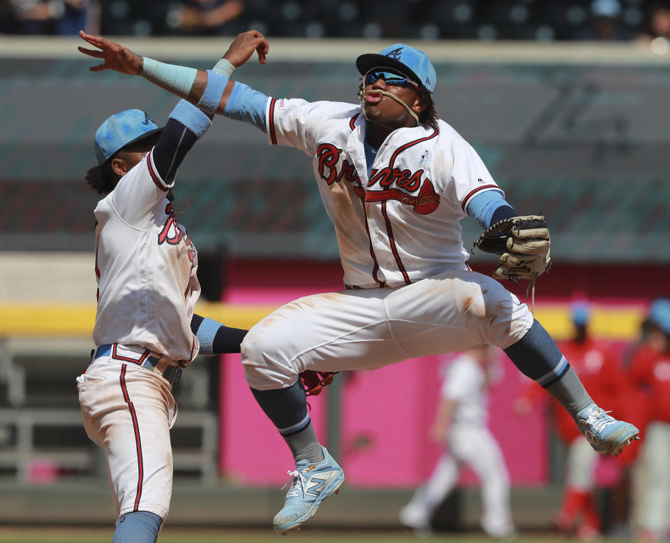 Atlanta Braves' Ronald Acuna Jr., right, and Ozzie Albies celebrate a victory over the Philadelphia Phillies in a baseball game Sunday, June 16, 2019, in Atlanta. (Curtis Compton/Atlanta Journal-Constitution via AP)