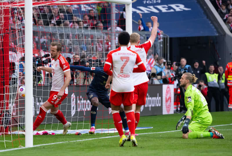 Bayern Munich's Harry Kane (L) scores his side's seventh goal of the game during the German Bundesliga Soccer match between Bayern Munich and FSV Mainz 05 at the Allianz Arena. Sven Hoppe/dpa
