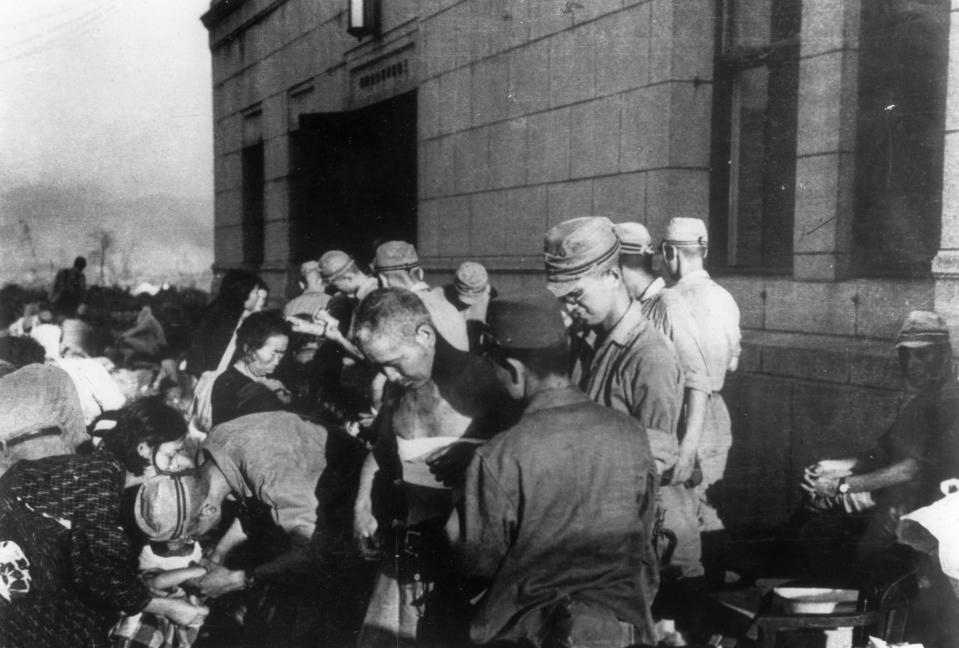 Shortly after the first atomic bomb ever used in warfare was dropped by the United States over the Japanese city of Hiroshima, survivors are seen as they receive emergency treatment by military medics on  Aug. 6, 1945. 