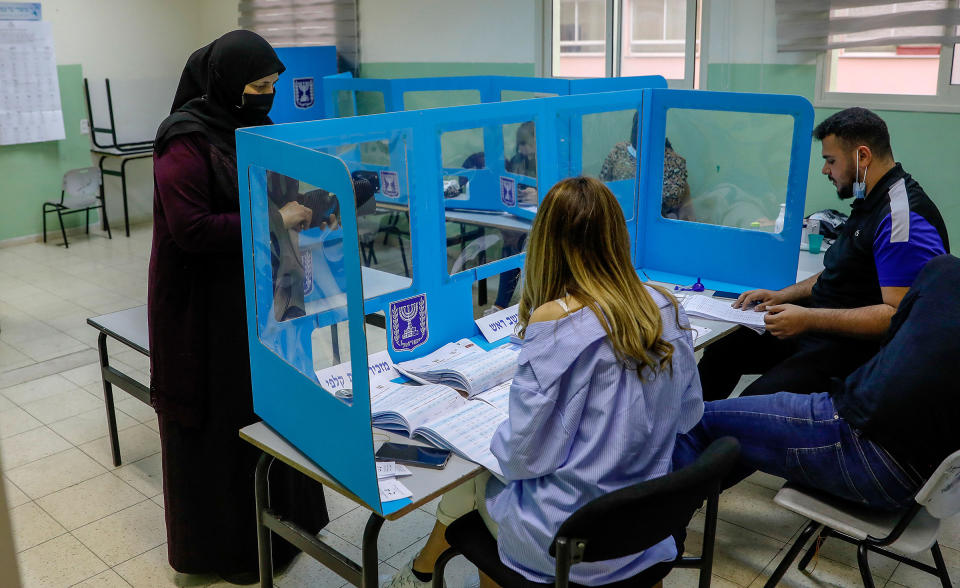 An Israeli Arab voter casts her ballot at a polling station in Kafr Manda, 16 kilometres northwest of Nazareth, on March 23, 2021.<span class="copyright">Ahmad Gharabli—AFP/Getty Images</span>