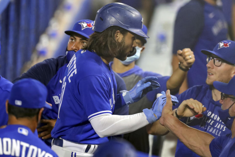 Toronto Blue Jays' Bo Bichette, center, is congratulated on his two-run home run against the Atlanta Braves during the third inning of a baseball game Friday, April 30, 2021, in Dunedin, Fla. (AP Photo/Mike Carlson)