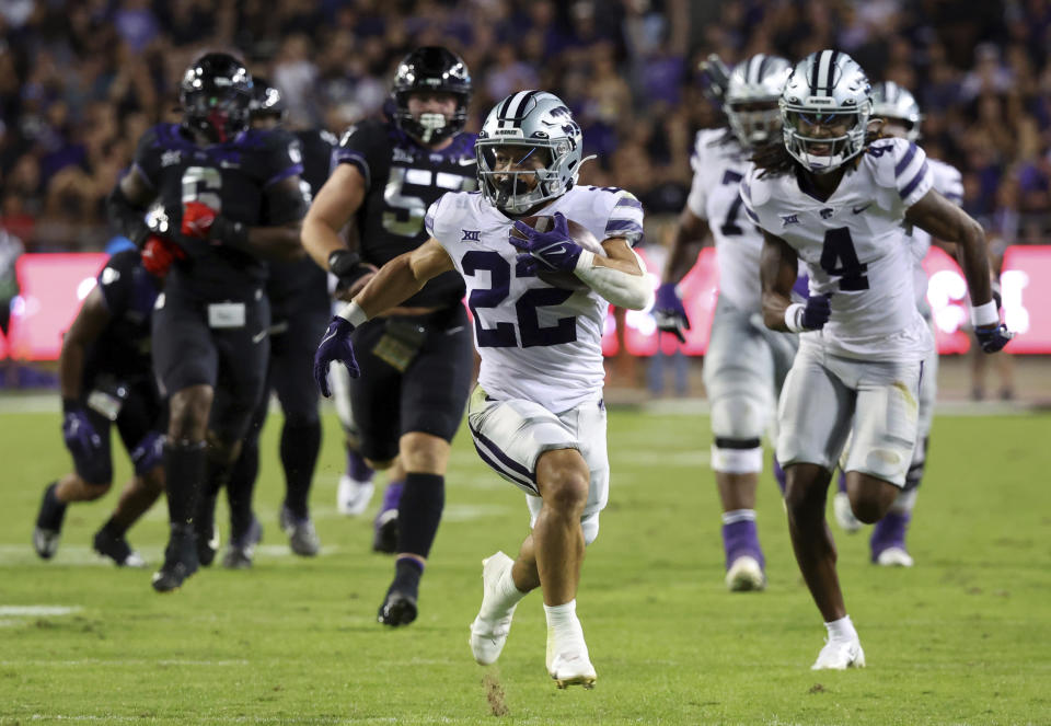 FILE - Kansas State running back Deuce Vaughn (22) carries the ball on a touchdown run during the first half of the team's NCAA college football game against TCU Saturday, Oct. 22, 2022, in Fort Worth, Texas. The body types are certainly much different for TCU's Kendre Miller and Kansas State's 5-foot-6 dynamo Deuce Vaughn. And yet the running backs that will be featured in the Big 12 championship game look pretty similar in what they do on the field. (AP Photo/Richard W. Rodriguez, File)