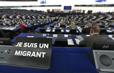 A leaflet with the slogan "I am a migrant" is placed on the desk of a Member of the European Parliament during a debate on the latest tragedies in the Mediterranean and E.U. migration and asylum policies at the European Parliament in Strasbourg, France, in this April 29, 2015 file photo. REUTERS/Vincent Kessler