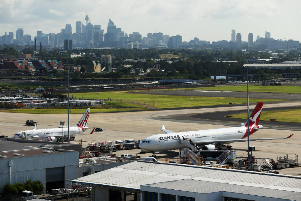 An Airbus SAS A330-300 aircraft operated by Qantas Airways Ltd., right, and a Boeing Co. 737-800 aircraft operated by Virgin Australia Holdings Ltd. stand at Sydney Airport.