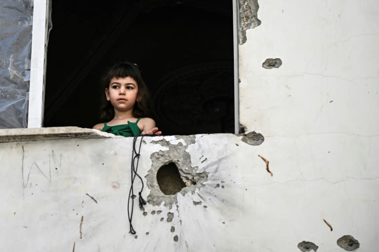 A Palestinian girl at the window of a shrapnel-pocked building in Jenin after the raid (RONALDO SCHEMIDT)