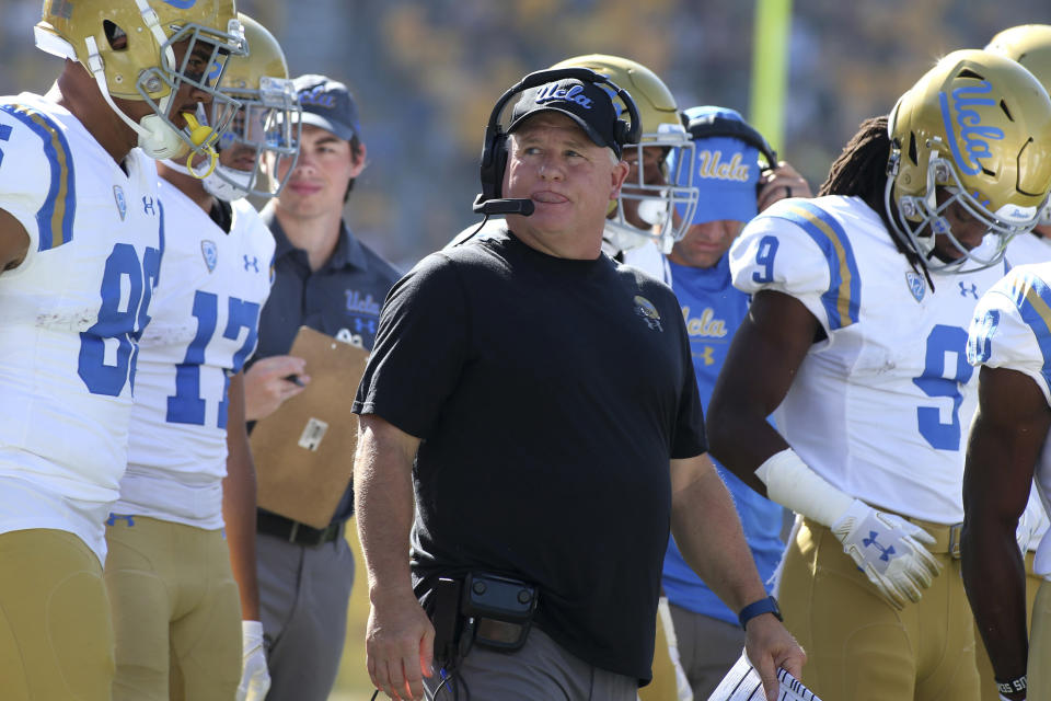 FILE - In this Nov. 10, 2018, file photo, UCLA head coach Chip Kelly, center, walks with his players prior to an NCAA college football game against Arizona State, in Tempe, Ariz. Chip Kelly isn’t a fan of momentum and how it can impact a team, but the UCLA coach admitted that the Bruins performance over the second half of last season, that included a win over crosstown rival USC, provided a boost coming into this year.  (AP Photo/Ralph Freso, File)