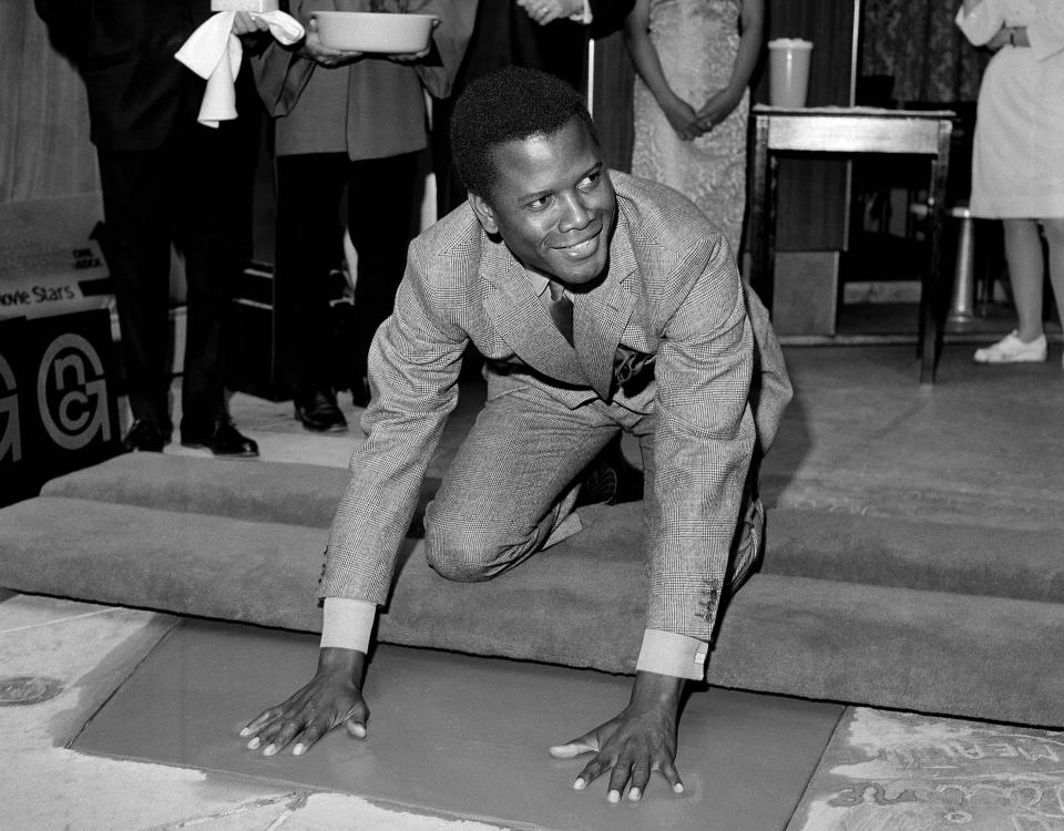 REMOVES REFERENCE TO THE BAHAMAS - FILE - Sidney Poitier, star of "To Sir With Love," places his hands in wet cement at Grauman's Chinese Theater in Los Angeles on June 23, 1967. Poitier, the groundbreaking actor and enduring inspiration who transformed how Black people were portrayed on screen, became the first Black actor to win an Academy Award for best lead performance and the first to be a top box-office draw, died Thursday, Jan. 6, 2022. He was 94. (AP Photo/File)