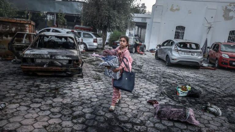 Una niña recolecta pertenencias cerca del hospital que fue atacado en Gaza