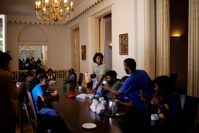 People eat breakfast inside a conference hall at the President Rajapaksa's house in Colombo