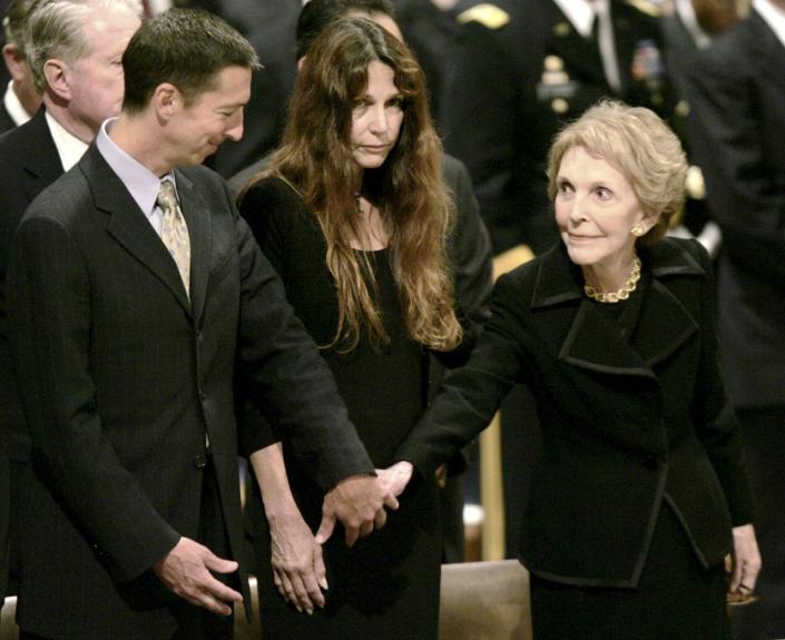 Nancy Reagan reaches out to Ron Reagan as Patti Davis looks on during the f...