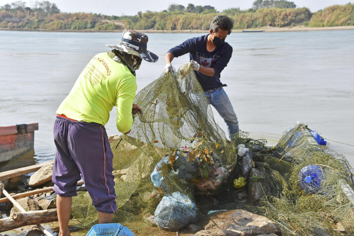 Officials collect plastic waste from the Mekong River in Vientiane, Laos, in 2020.  (Kyodo / AP file)