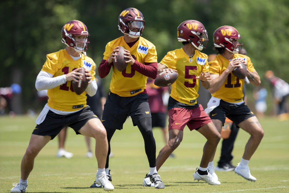 Washington Commanders quarterbacks, from left, Jeff Driskel (16), Marcus Mariota, (0), Javden Daniels (5) and Sam Hartman (11) throw a passes during NFL football practice in Ashburn, Va., Wednesday, May 22, 2024. (AP Photo/Jose Luis Magana)