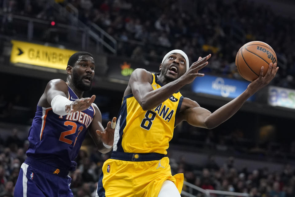 Indiana Pacers' Justin Holiday (8) looks to shoot against Phoenix Suns' Deandre Ayton (22) during the first half of an NBA basketball game, Friday, Jan. 14, 2022, in Indianapolis. (AP Photo/Darron Cummings)