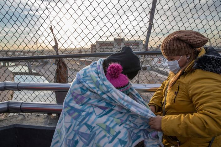 In this file photo from early 2021, after two years of waiting in Mexico under MPP, a migrant from Guatemala and her two children hope to be able to finally enter the U.S. at the Paso del Norte bridge in Ciudad Ju&#xe1;rez, Mexico.