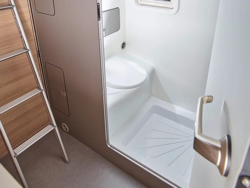 A bathroom next to a ladder in the van.