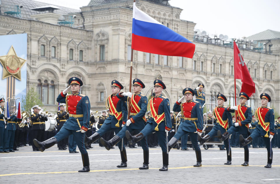 Una guardia de honor rusa desfila con una bandera nacional y una réplica de la bandera de la Victoria durante un desfile por el 74to aniversario de la victoria en la Segunda Guerra Mundial, en la Plaza Roja, Moscú, el 9 de mayo de 2019. (AP Foto/Alexander Zemlianichenko)