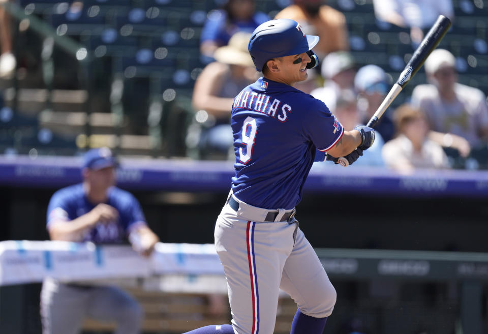 Texas Rangers' Mark Mathias follows the flight of his double to drive in three runs off Colorado Rockies starting pitcher Jose Urena in the second inning of a baseball game Wednesday, Aug. 24, 2022, in Denver. (AP Photo/David Zalubowski)