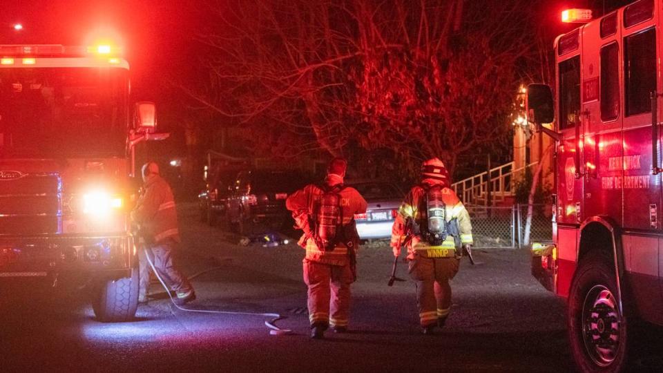 Firefighters work to extinguish a fire at a home on Quincy Street in Kennewick. The blaze left a man in critical condition.