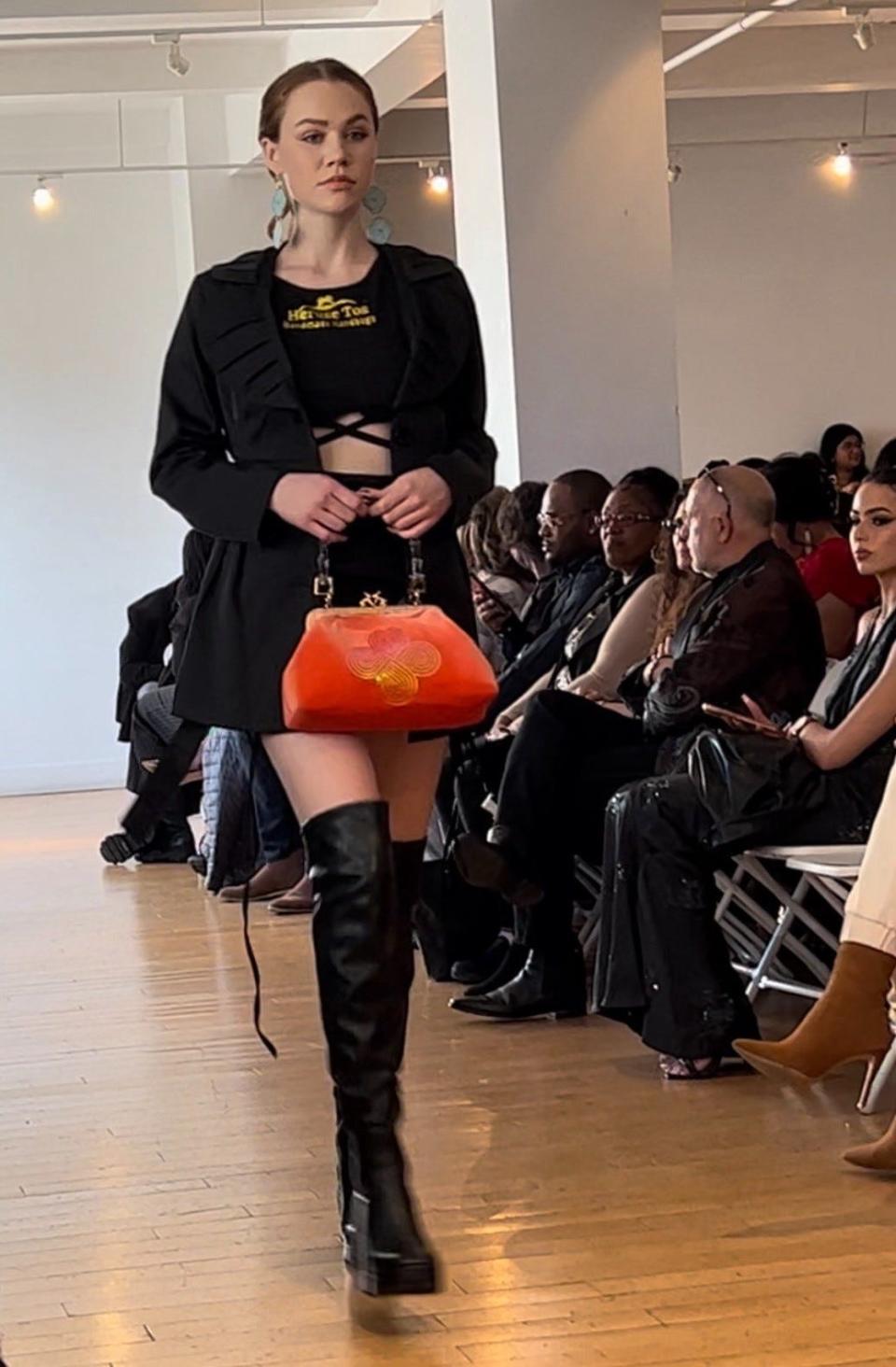 A model walks the runway at the 2023 Rise NYFW showcase during New York Fashion Week carrying a purse from Claremore-based Muscogee designer Lea McCormick's Heruse tos Handmade Handbags.