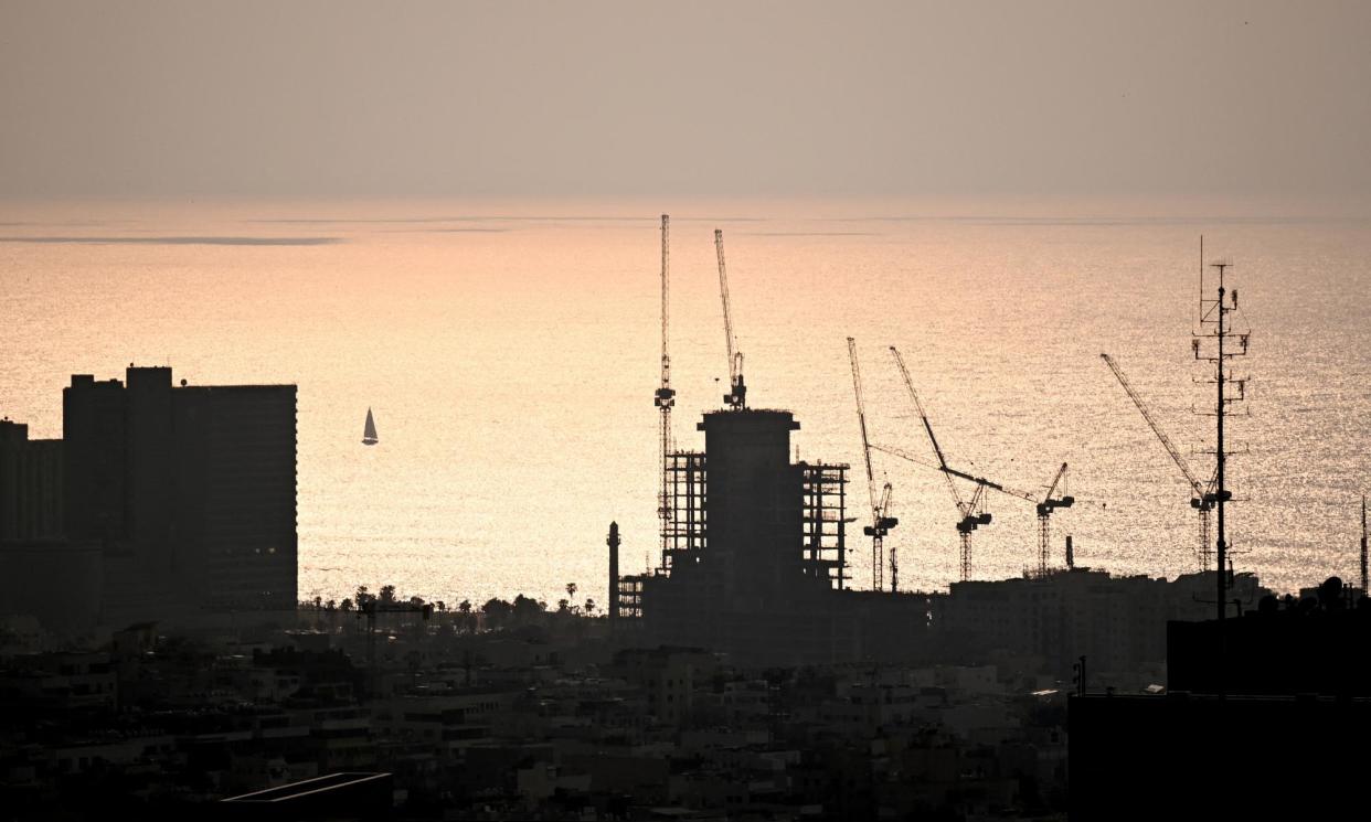 <span>Cranes under the sunset in Tel Aviv amid the ongoing conflict between Israel and Hamas.</span><span>Photograph: Dylan Martinez/Reuters</span>