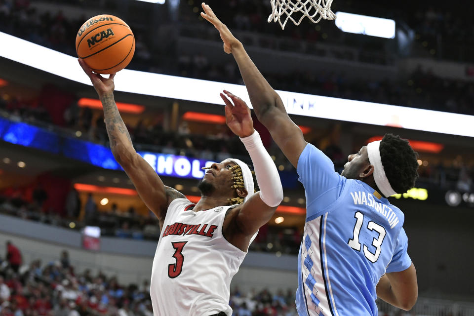 Louisville guard El Ellis (3) attempts a reverse layup over North Carolina forward Jalen Washington (13) during the second half of an NCAA college basketball game in Louisville, Ky., Saturday, Jan. 14, 2023. North Carolina won 80-59. (AP Photo/Timothy D. Easley)