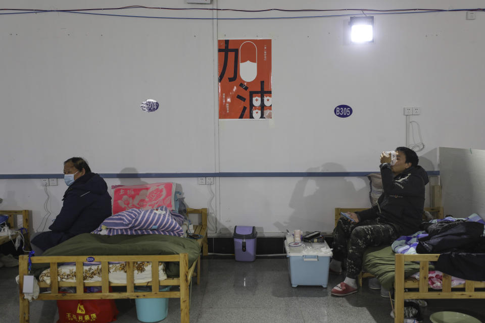 In this Friday, Feb. 21, 2020, photo, a man eats a meal at a temporary hospital at Tazihu Gymnasium in Wuhan in central China's Hubei province. China's leadership sounded a cautious note Friday about the country's progress in halting the spread of the new virus that has now killed more than 2,200 people, after several days of upbeat messages. (Chinatopix via AP)