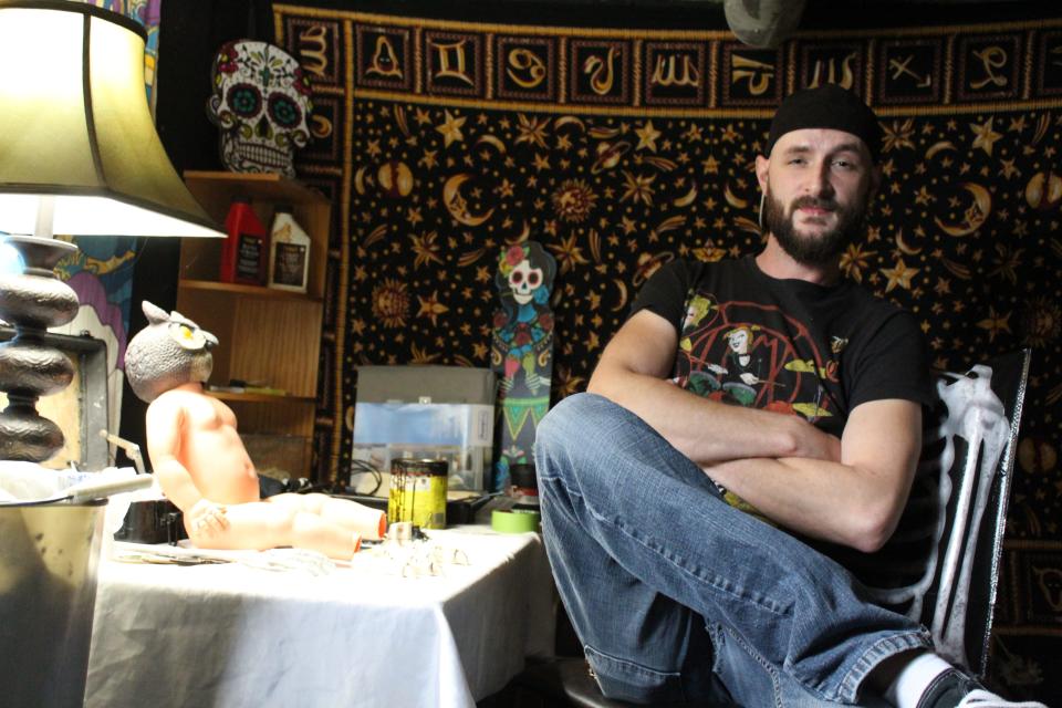 Monroe artist Kody Clark, 31, sits in his basement studio where he creates unique and unusual pieces of art.