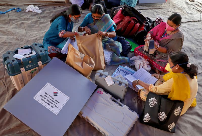 Polling officials check election materials after collecting them from a distribution centre, in Purulia