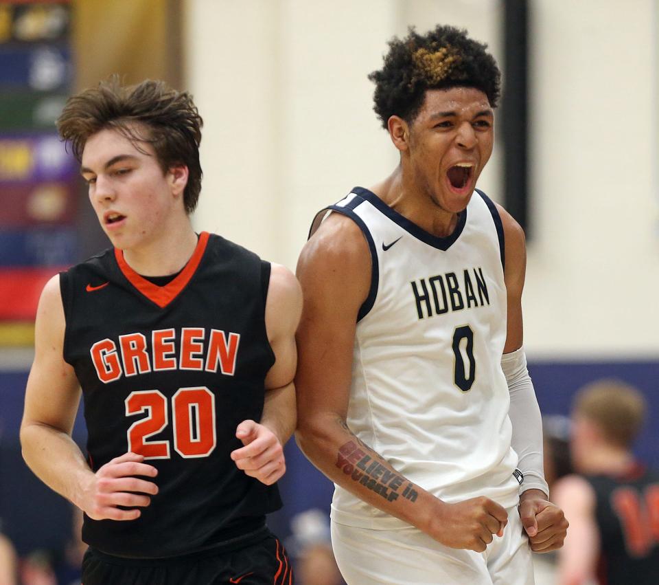 Hoban guard Jonas Nichols, right, celebrates after hitting the game-tying 3-pointer beside Green forward Brady Rollyson late in the fourth quarter of a 2022 Division I regional semifinal at Copley High School.