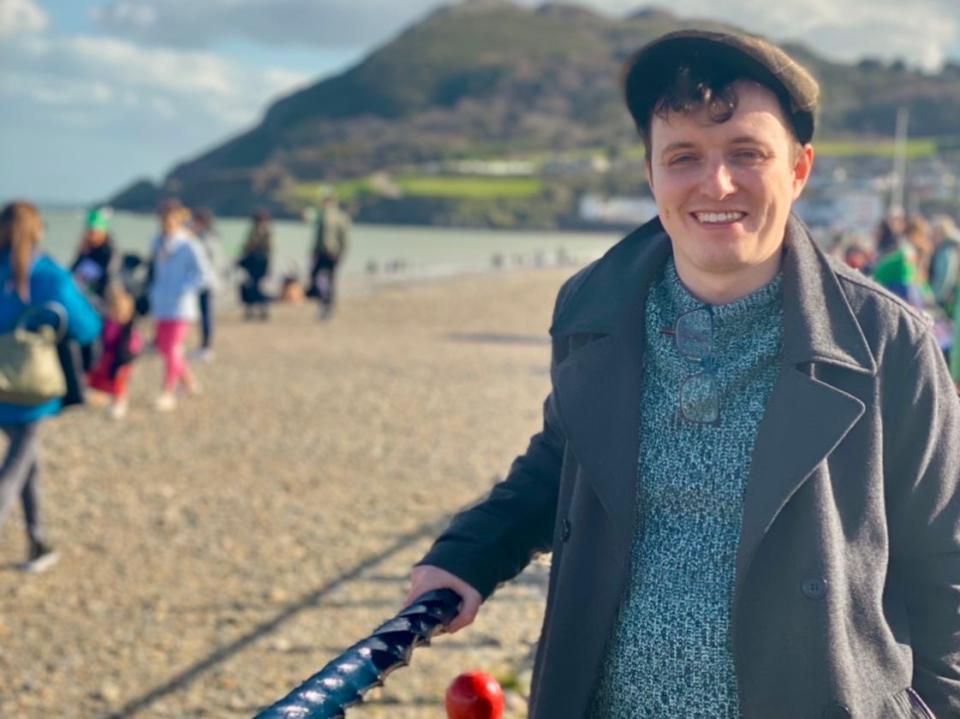 alexis' partner posing for a photo on a beach in ireland