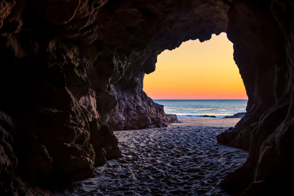 looking out of a beach cave at sunset, leo carillo state beach, california