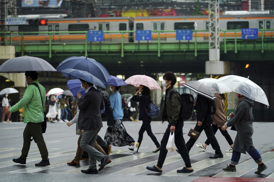 People wearing protective masks to help curb the spread of the coronavirus walk along a pedestrian crossing Thursday, May 13, 2021, in Tokyo. The Japanese capital confirmed more than 1,000 new coronavirus cases on Thursday. (AP Photo/Eugene Hoshiko)