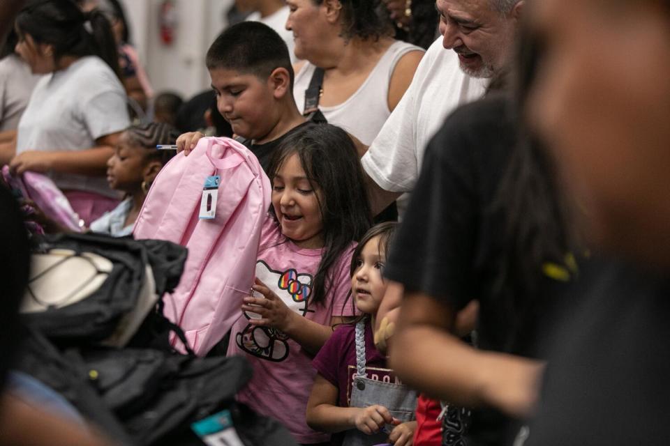 Eager children and parents move through the line to receive free backpacks and school supplies.