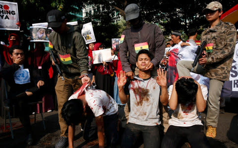 Indonesian Muslim activists in Jakarta stage an execution during a protest against Myanmar's alleged persecution of its Muslim Rohingya minority  - Credit: EPA/ADI WEDA