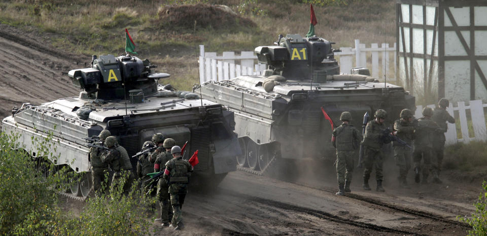 FILE - Soldiers follow a Marder infantry fighting vehicle during a demonstration event held for the media by the German Bundeswehr in Bergen near Hannover, Germany, Wednesday, Sept. 28, 2011. The U.S. and Germany are sending Ukraine an array of armored vehicles, including 50 tank-killing Bradleys, to expand its ability to move troops to the front lines and beef up its forces against Russia as the war nears its first anniversary. (AP Photo/Michael Sohn, File)