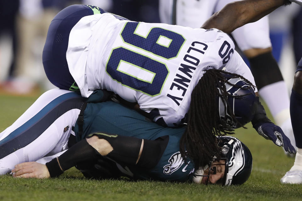 FILE - In this Jan. 5, 2020, file photo, Philadelphia Eagles' Carson Wentz is hit by Seattle Seahawks' Jadeveon Clowney (90) during the first half of an NFL wild-card playoff football game in Philadelphia. The Browns remain interested in Clowney, the talented defensive end _ and former No. 1 overall draft pick _ who remains unsigned and the top target on the free agent market. During a Zoom meeting with reporters on Thursday, May 28, 2020, Browns new defensive coordinator Joe Wood praised Clowney but deferrred any questions about the Browns' pursuit of the speedy edge rusher to general manager Andrew Berry.(AP Photo/Julio Cortez, File)