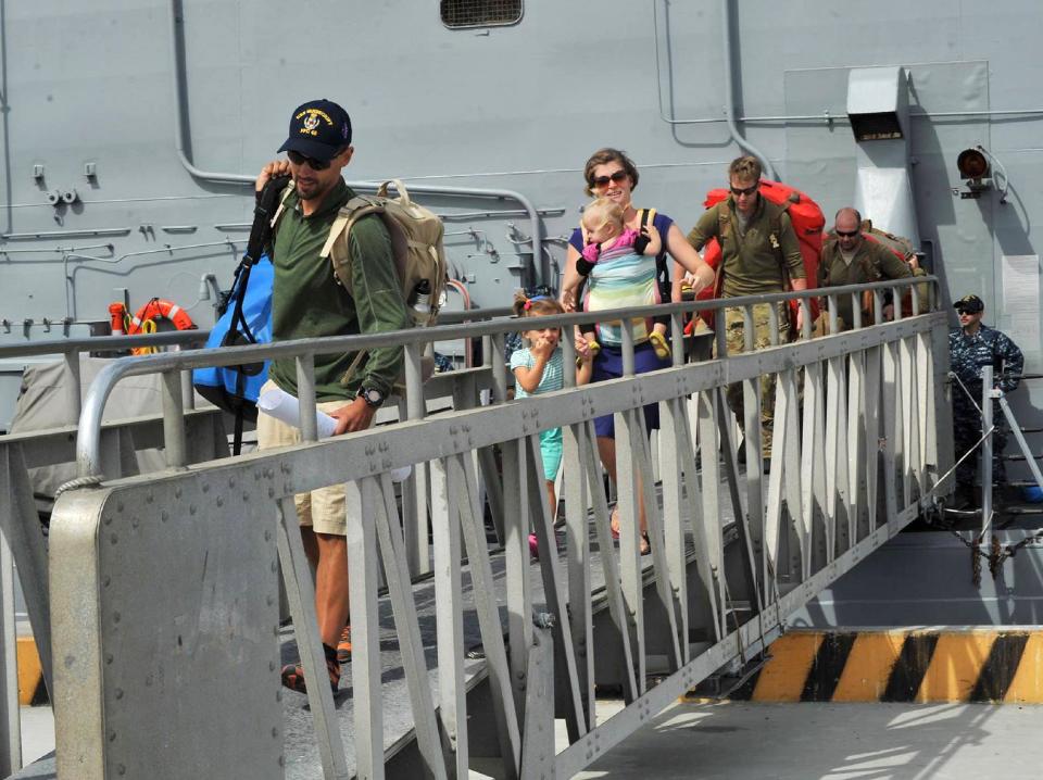 This photo provided by the U.S. Navy shows the Kaufman family disembarking from the USS Vandegrift on Wednesday, April 9, 2014, at Naval Air Station North Island in San Diego, following their rescue at sea on April 6. Six days after the family of four found themselves helpless and adrift in a sailboat far into the Pacific with a vomiting and feverish 1-year-old aboard, a Navy warship delivered them safely to shore, where they had begun their attempted around-the world voyage before the child was born. (AP Photo/U.S. Navy)