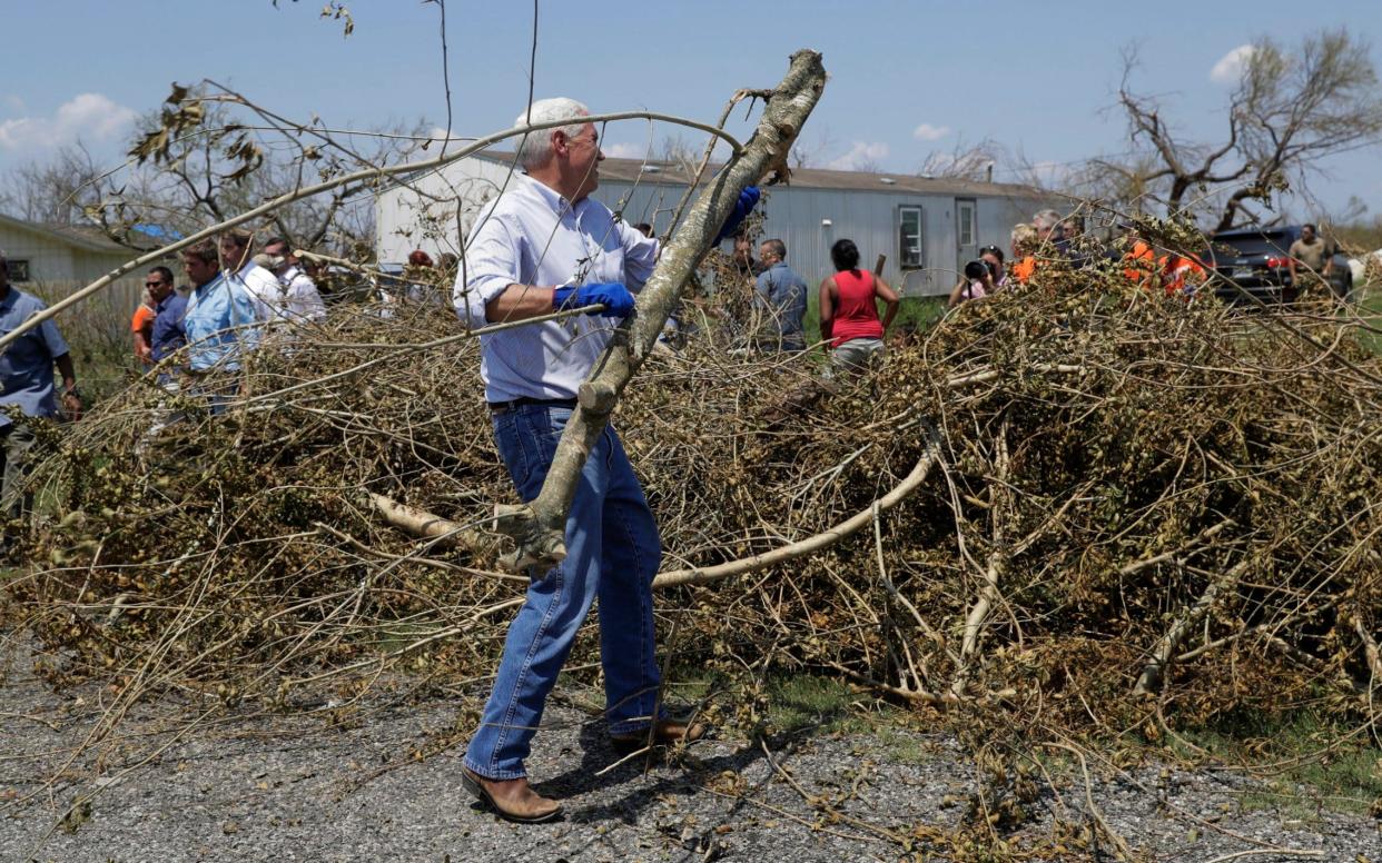 Vice President Mike Pence helps move debris during a visit to an area hit by Hurricane Harvey, Thursday, Aug. 31, 2017, in Rockport, Texas - AP