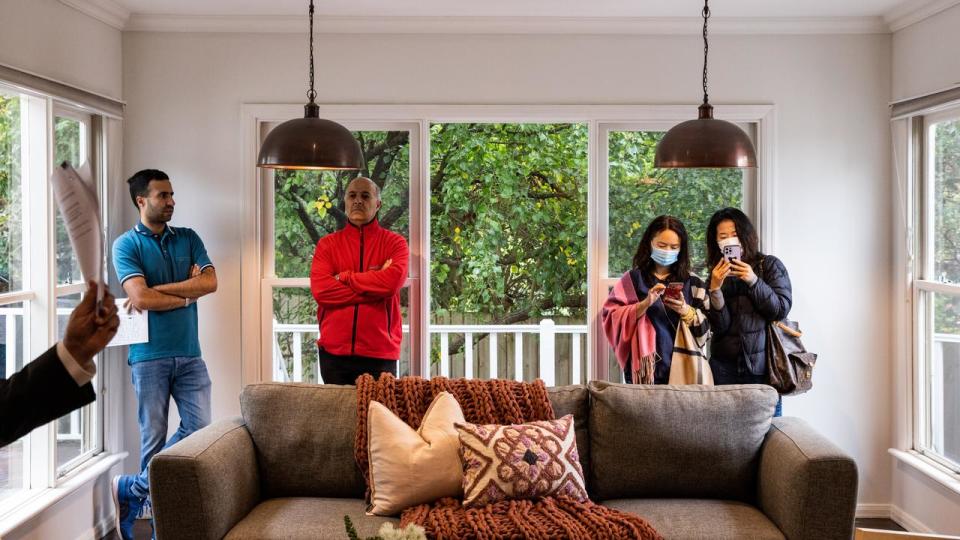 Bidders gather inside a home during an auction