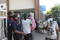 Nigeria civil servants show their COVID-19 vaccine certificates to security officers before being allowed access to their office in Abuja, Nigeria , Wednesday, Dec. 1, 2021. Nigeria has detected its first case of the omicron coronavirus variant in travelers that arrived from South Africa in the past week, the country’s national public health institute said Wednesday, correcting its earlier statement that it found the variant in samples taken in October. (AP Photo/Gbemiga Olamikan)