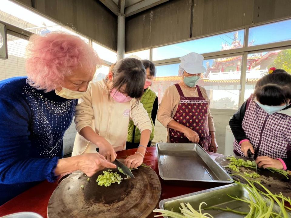 大光國小學童與中寮社區的長者合作料理古早味海產粥。（大光國小提供）