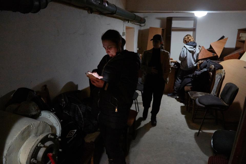 Residents in Kyiv follow the news inside a bomb shelter.