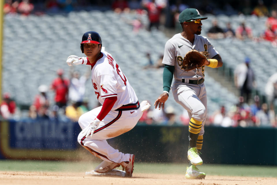 Los Angeles Angels designated hitter Shohei Ohtani, left, slides into second with an RBI-double as Oakland Athletics second baseman Tony Kemp, right, gets out the way during the third inning of a baseball game in Anaheim, Calif., Saturday, July 31, 2021. (AP Photo/Alex Gallardo)