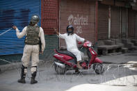 A Kashmiri man requests a paramilitary soldier to let him through during curfew in Srinagar, Indian controlled Kashmir, Tuesday, Aug. 4, 2020. Authorities clamped a curfew in many parts of Indian-controlled Kashmir on Tuesday, a day ahead of the first anniversary of India’s controversial decision to revoke the disputed region’s semi-autonomy. Shahid Iqbal Choudhary, a civil administrator, said the security lockdown was clamped in the region’s main city of Srinagar in view of information about protests planned by anti-India groups to mark Aug. 5 as “black day." (AP Photo/Mukhtar Khan)