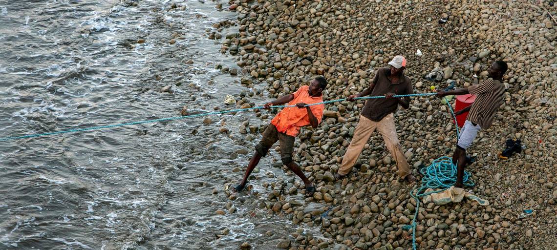 Men from the fishing community of Bodin on the outskirts of Port-de-Paix pull in a fishnet on March 24, 2022. Residents here say the lack of jobs and fish are among the reasons some have taken their chances trying to get to the Florida Keys on flimsy vessels.